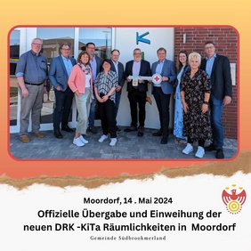 Mehrere Männer und Frauen stehen nebeneinander und lächeln in die Kamera. Zwei Personen halten einen großen Schlüssel.