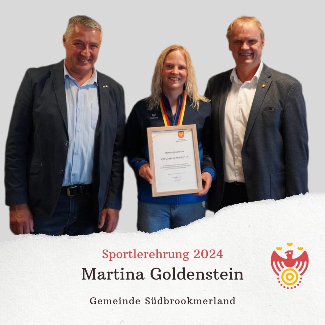 Zwei Männer und eine Frau lächeln in die Kamera. Die Frau hält eine Urkunde und trägt eine Medaille