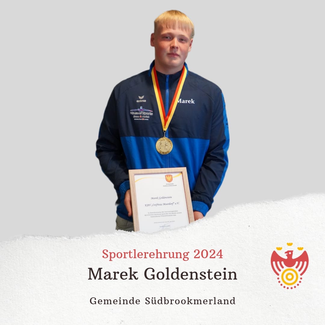 Marek Goldenstein hält eine Urkunde, trägt eine Medaille um den Hals und lächelt in die Kamera