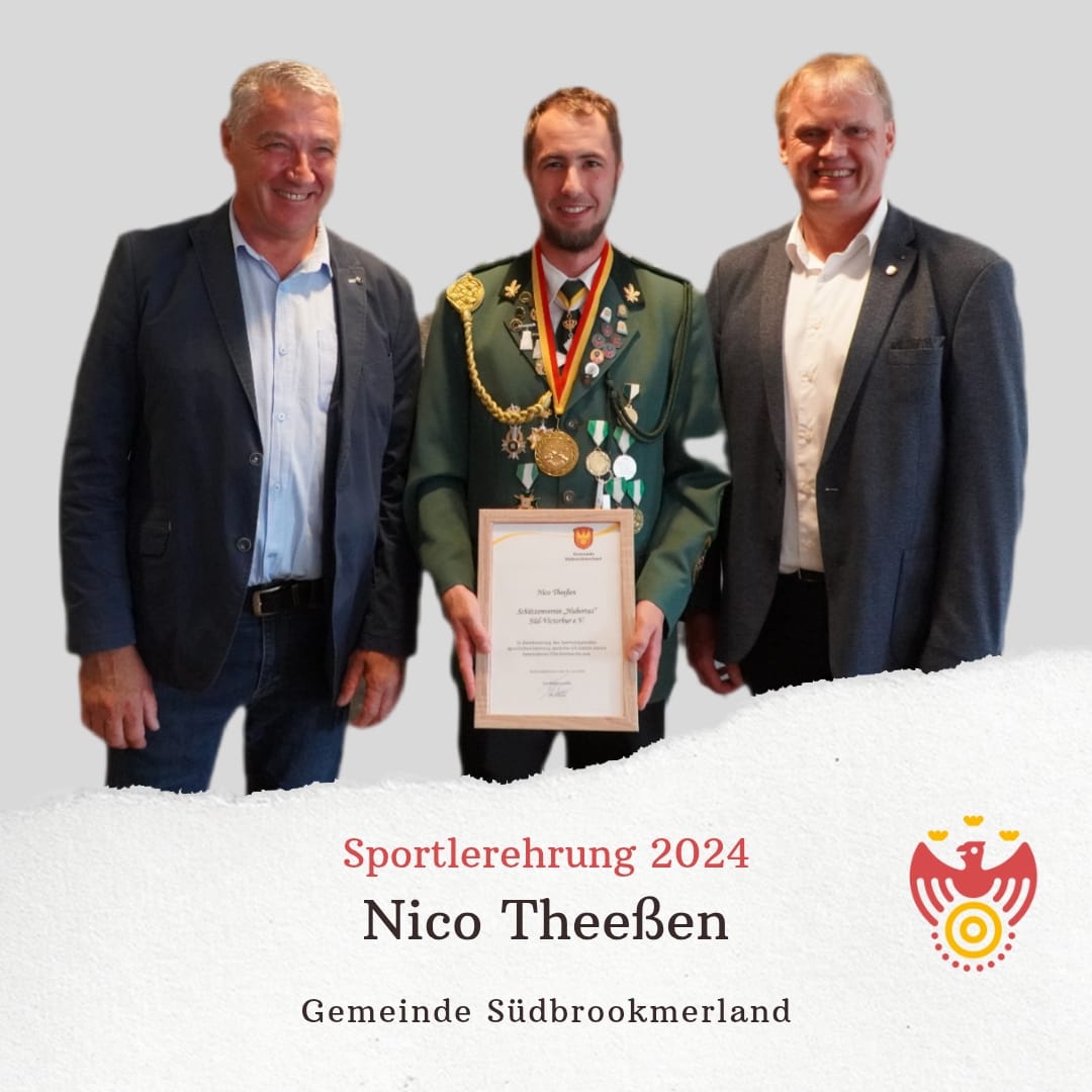 Drei Personen lächeln in die Kamera. Eine Person hält eine Urkunde und trägt eine Medaille um den Hals